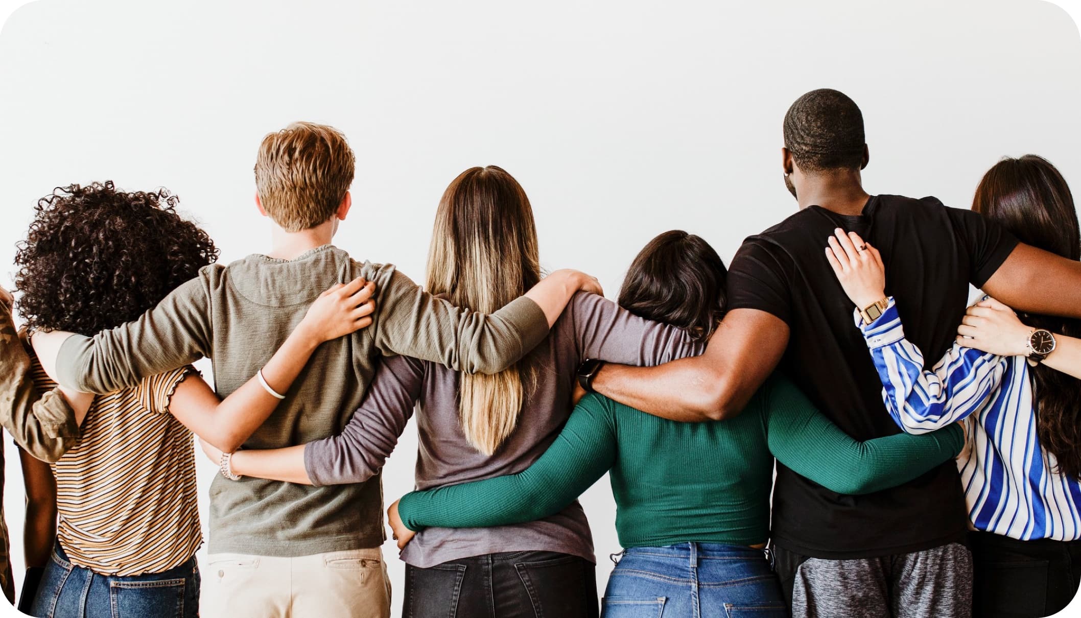 A group of people standing arm in arm