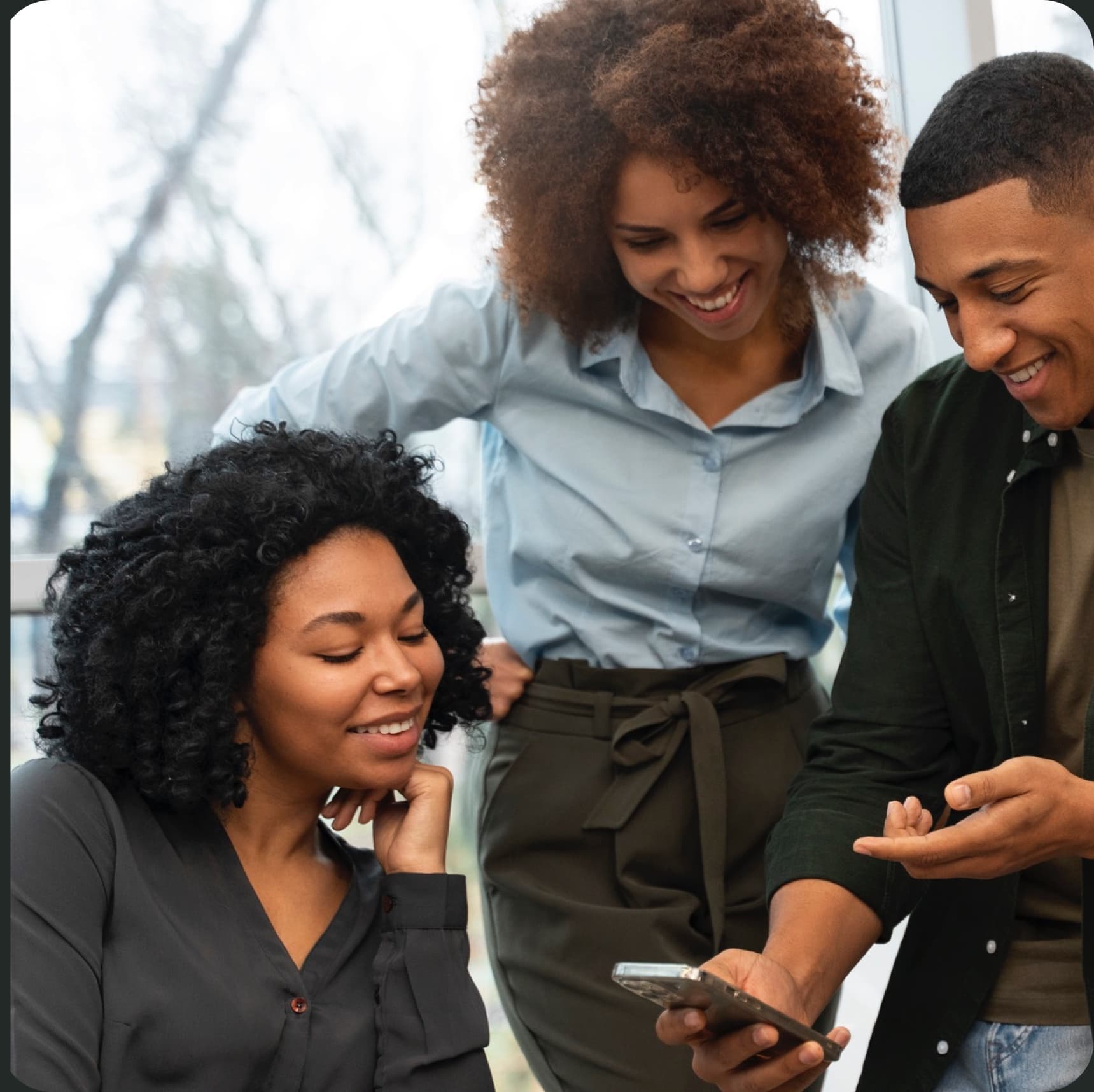 Three friends looking at a phone together